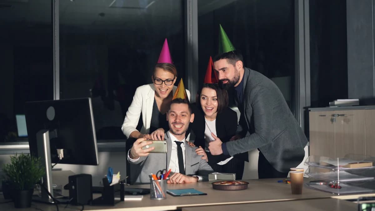 Coworkers taking a group selfie at an office party
